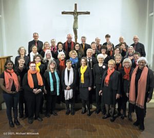 Das Foto zeigt den Gosplechor Cantanova der Heilig-Geist-Kirche in Bergisch Gladbach. Darauf sind ca. 40 schwarz gekleidete Personen mit verschieden farbigen Schals zu sehen, die Sängerinnen und Sänger des Chores.